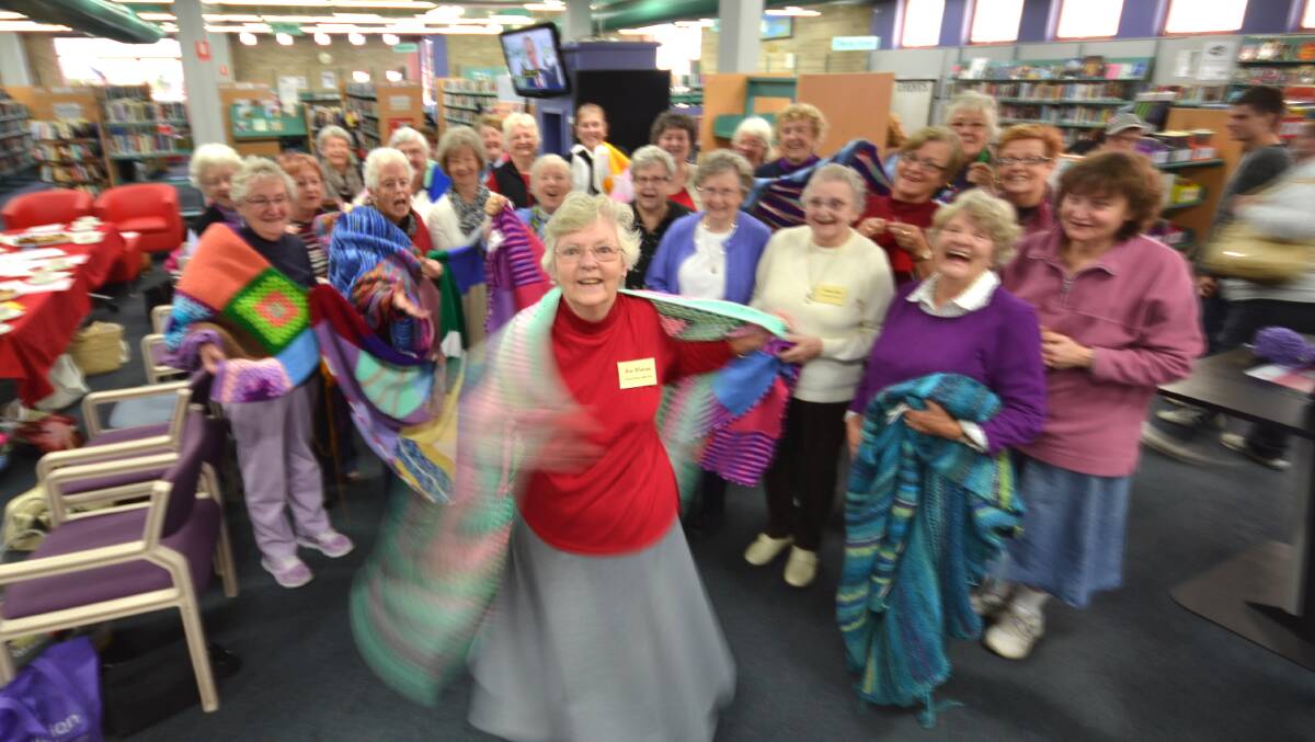 KNITTING SISTERHOOD: Nowra Wrap with Love co-ordinator Rae Watson twirls in front of fellow wrappers during their annual morning tea at the Nowra Library on Tuesday.