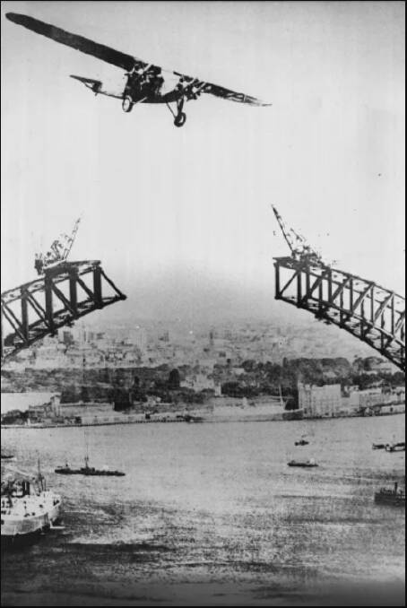 The plane flies over the Sydney Harbour Bridge during construction. 