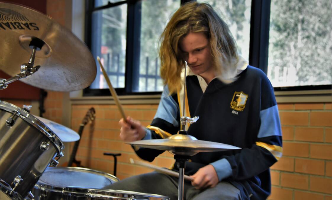 TALENT: Duo member Alex Robertson jamming on the drums.