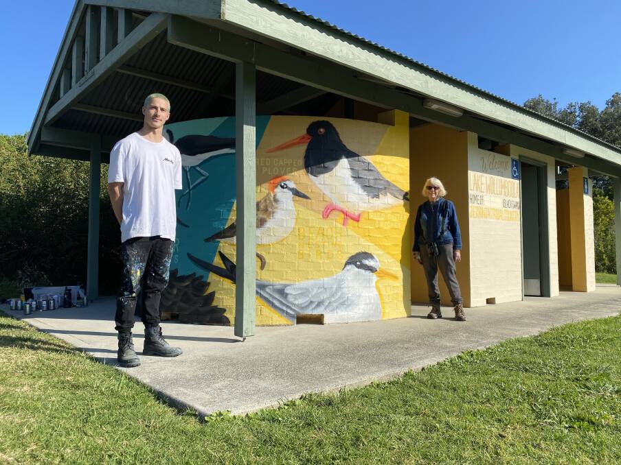Bird work: Artist Sam Hall with President of the Lake Wollumboola Protection Association Frances Bray in front of the new mural painted on a toilet block near The Lake Cul-de-sac.