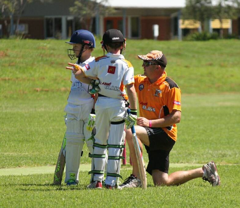Andrew Malcolm coaches two youngsters from the Batemans Bay Cricket Club. Photo: Shoalhaven District Junior Cricket Association.