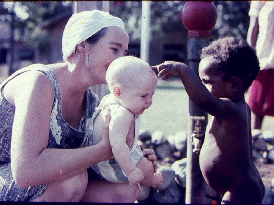 Dr Howard in a theatre cap with the couple's eldest daughter Kate in the grounds of the Goroka Hospital also in 1965.

