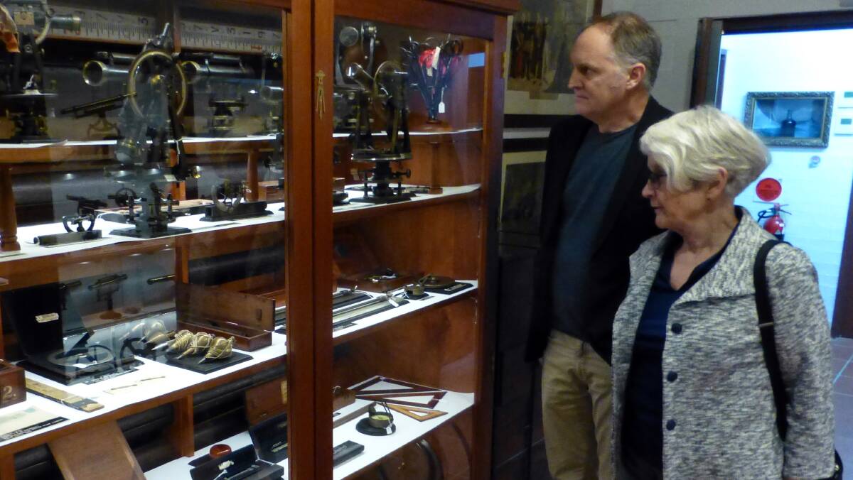 GREAT TO SEE: Members of the Halloran family Jennifer Brookes and James Larcombe admire the quality of the lighting over their grandfather’s collection of surveying instruments.