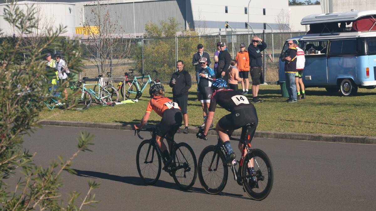 NVC criteriums, Robert Packer and Levi Johns race past the Bearded Brewer and patrons.