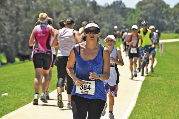 TRYING CONDITIONS:  As the mercury made its way into the 30s yesterday hundreds of competitors made their way around the Nowra Triathlon course. Hundreds of spectators also worked up a sweat in the humid conditions. For more on the triathlon see page 40. Photo DAYLE LATHAM