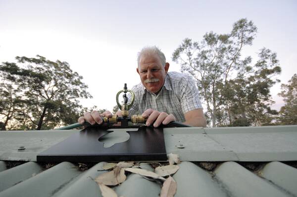 DAMP DOWN: Gordon McKeown of Callala Bay with his simple system to protect homes from ember attack during bushfires. Photo: ADAM WRIGHT