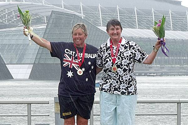 SUCCESS: Wrights Beach kayaker Dianne Chellew and fellow Aussie, Olympian Margaret Buck show off their K2 medal at the World Marathon Canoe Championships in Singapore. Even the pouring rain couldn’t dampen their smiles.