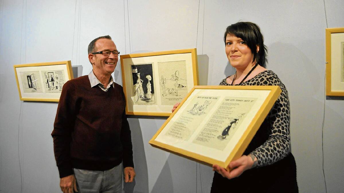 HERITAGE: Fleet Air Arm Museum manager Terry Hetherington and Shoalhaven City Arts Centre assistant Anna Christoffersen with two of the works in Navy in Black and White, now on display.