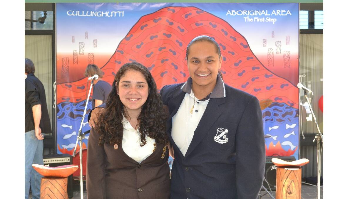 Talesha Farrell from Orient Point representing Shoalhaven High School and Jenayha Helmons from Worrigee representing Nowra High School stand with the Cullunghutti banner at the Cullunghutti Aboriginal Area community celebration at the Shoalhaven Heads Community Centre on Friday.