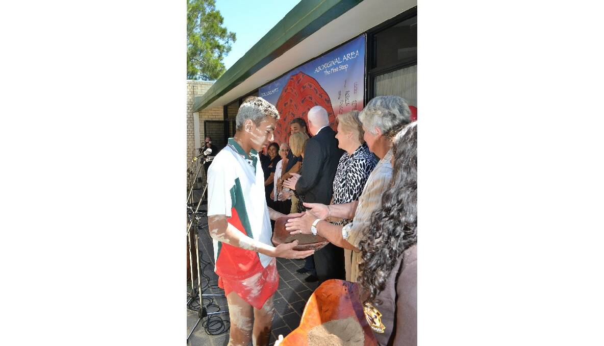 Bomaderry High School student representative carries the Coolamon to the dignitaries where they place their collected Cullunghutti soil as part of the traditional cultural ceremony at the Cullunghutti Aboriginal Area community celebration at the Shoalhaven Heads Community Centre on Friday.