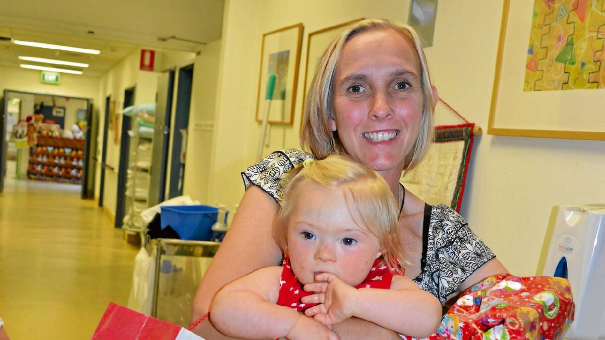 RIGHT: KIND GIFTS: Judy Davies is overwhelmed by the kindness shown to her and her daughter Lilly-Rose Middleton-Davies as she receives vouchers for fuel and groceries from Bike Riders and Tourers of the Illawarra and Shoalhaven (BRAT) and early Christmas gifts from the nurses at the Shoalhaven Hospital children’s ward on Monday.