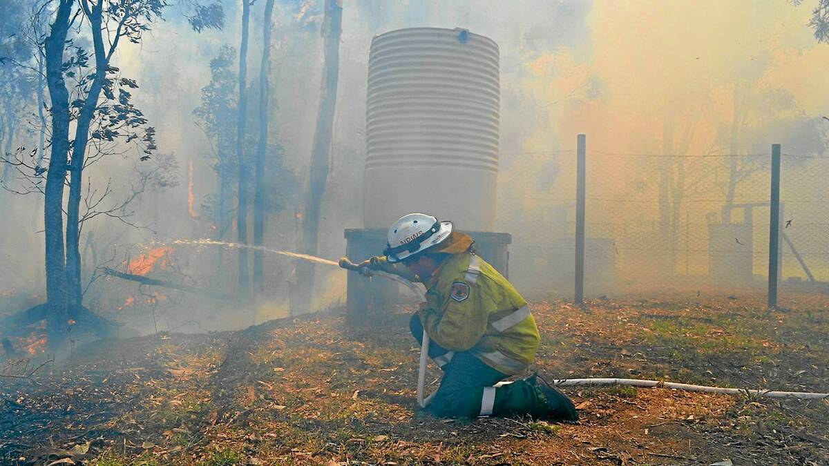 LOW VIS: A firefighter on property protection off Quinns Lane during yesterday’s fire that destroyed seven hectares.