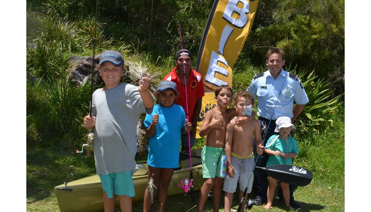 Tim Askew and Keyala Brown from Jervis Bay, Tristian Archibald from Kempsie, Ben Askew from Jervis Bay and Daisy Pipe with (back) CJ Thomas from South Coast Medical Service Aboriginal Corporation and AFP first constable Ben Pipe are all hoping to win the day’s major prize (a Hobie kayak package) at the Australian Federal Police and Wreck Bay indigenous community ‘Off the Hook’ kids’ fishing fun day at Summercloud Bay on Wednesday. 