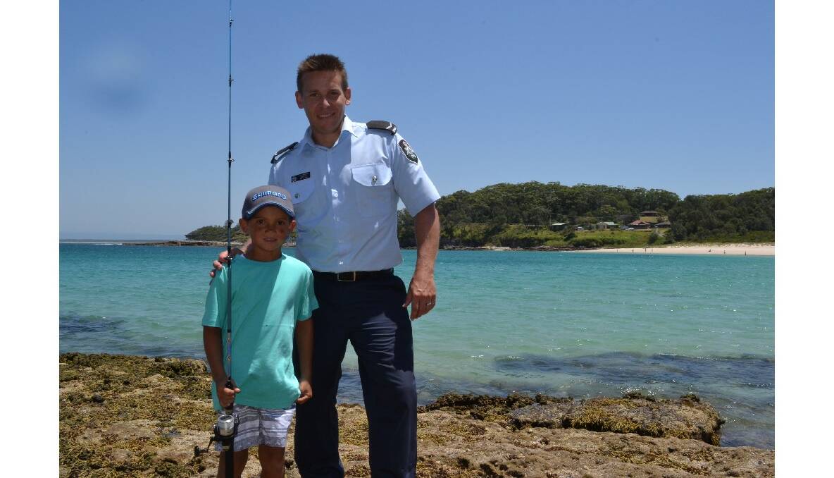 Six-year-old Tyler Brown from Jervis Bay is congratulated by AFP first constable Ben Pipe for catching the first fish of the day at the Australian Federal Police and Wreck Bay indigenous community ‘Off the Hook’ kids’ fishing fun day at Summercloud Bay on Wednesday. 