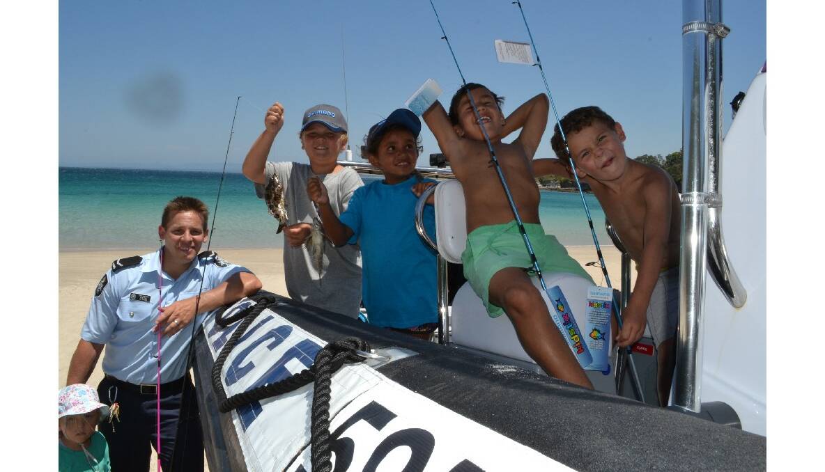 Daisy Pipe, AFP first constable Ben Pipe, Tim Askew and Keyala Brown from Jervis Bay, Tristian Archibald from Kempsie and Ben Askew from Jervis Bay check out the awesome police rescue boat at the Australian Federal Police and Wreck Bay Indigenous Community “Off the Hook” Kids Fishing Fun Day at Summercloud Bay on Wednesday.
