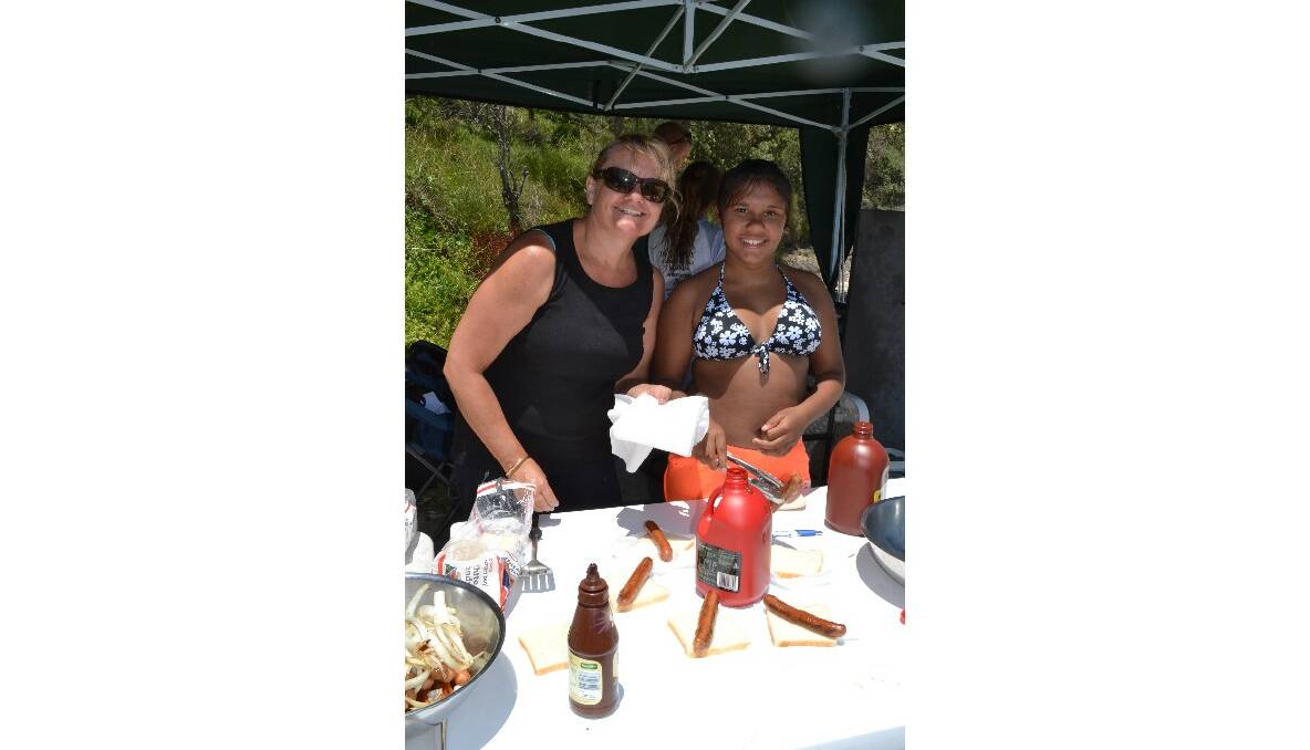 Mary Baseler and Jenayah Ingrey from Jervis Bay make sure everyone gets a free sausage sandwich at the Australian Federal Police and Wreck Bay indigenous community ‘Off the Hook’ kids’ fishing fun day at Summercloud Bay on Wednesday. 