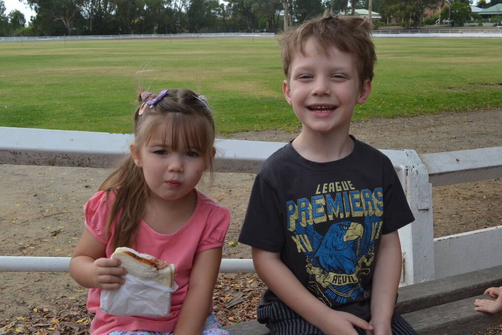 CHEERFUL: Luca Higginbotham and Harvey Ward from Worrigee have a bite to eat at the Nowra Lions Club Kid’s Day Out at the Nowra Showground on Sunday.