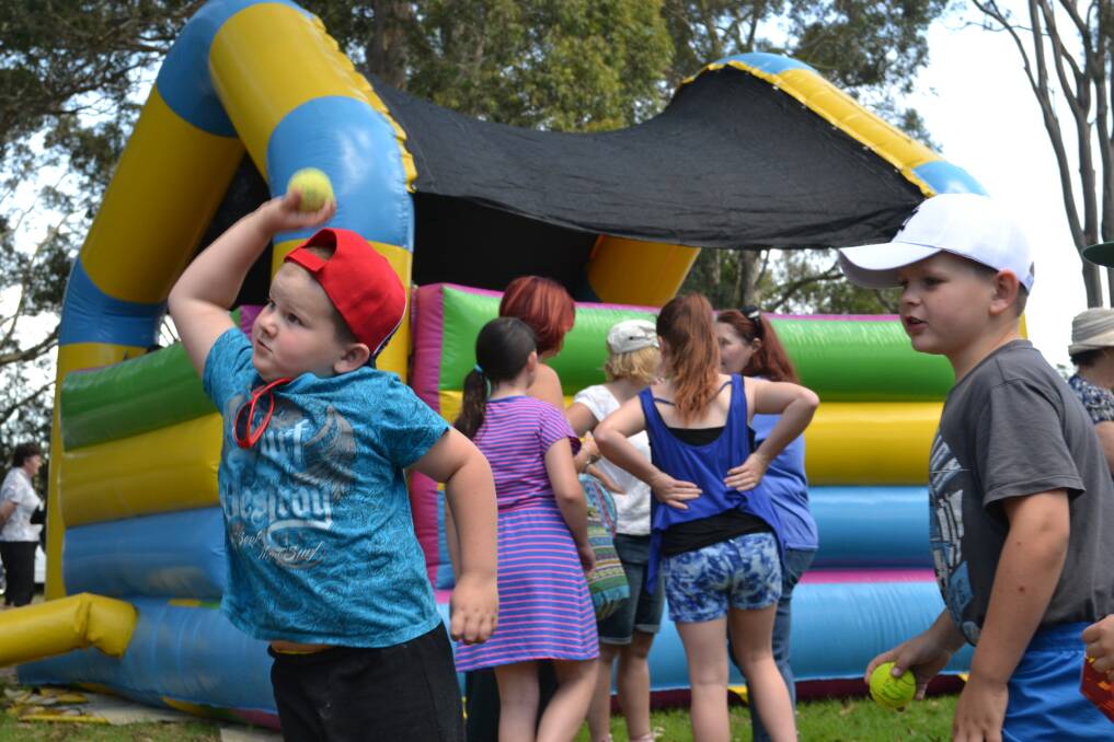 HUGE EFFORT: Charish Kennedy aims his throw as brother Sebastian looks on. The brothers from Vincentia are having fun at the Huskisson Anglican Church Free Christmas Family Fun Time on Sunday. 