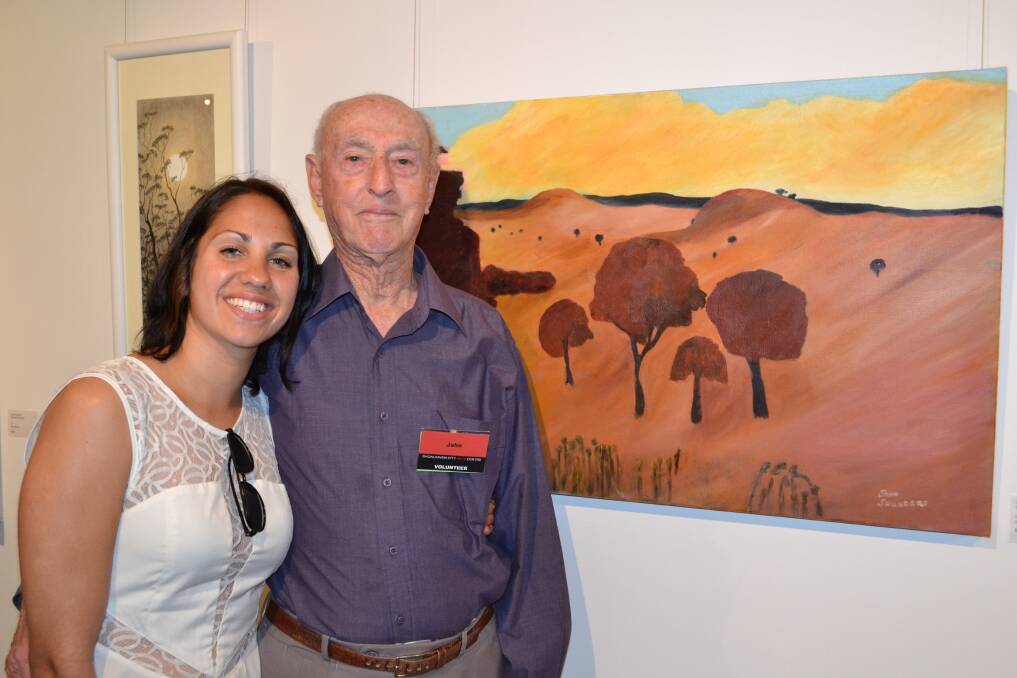 GREAT DAY: Kirli Saunders from Wollongong with her grandfather John Saunders and his painting over the grand divide at the NOW: Shoalhaven Contemporary Art Prize exhibition at the Shoalhaven City Arts Centre in Nowra on Saturday.