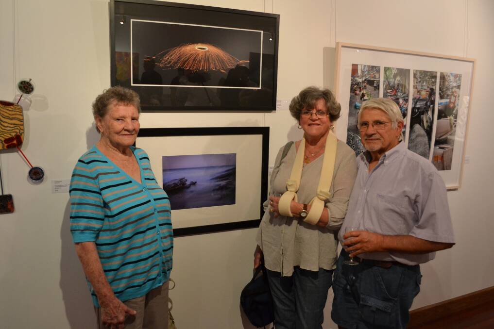 PHOTO WALL: Anni Bendl from Sussex Inlet, Christi and John Drysdale from Ulludulla with the exhibit sunset magic and enjoy the day at the NOW: Shoalhaven Contemporary Art Prize exhibition at the Shoalhaven City Arts Centre in Nowra on Saturday.