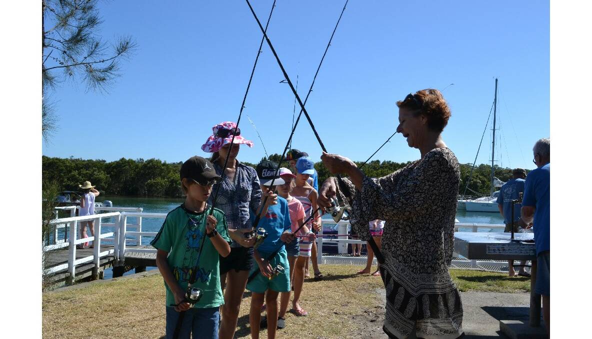 PRACICE: Huskisson RSL Fishing Club member Michelle Hurley explains to the children taking part in the club’s fishing school how to cast.