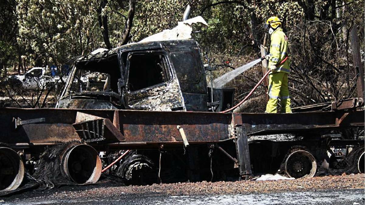 Bunbury police are looking for a small gold sedan which may piece together the cause of Wednesday's crash between a Main Road's line marking truck and a log truck, pictured, which caught fire. Photo: Andrew Elsterman/Bunbury Mail.