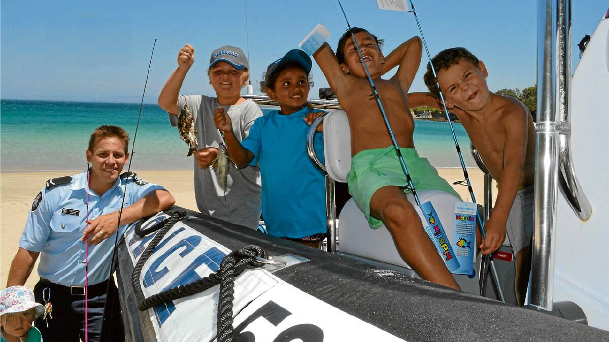 ACTION STATIONS: Daisy Pipe, AFP Constable Ben Pipe, Tim Askew and Keyala Brown from Jervis Bay, Tristian Archibald from Kempsey and Ben Askew from Jervis Bay check out the police rescue boat at the Australian Federal Police’s and Wreck Bay Indigenous Community’s Off the Hook Kids Fishing Fun Day at Summercloud Bay on Wednesday. For more photos from this event visit southcoastregister.com.au