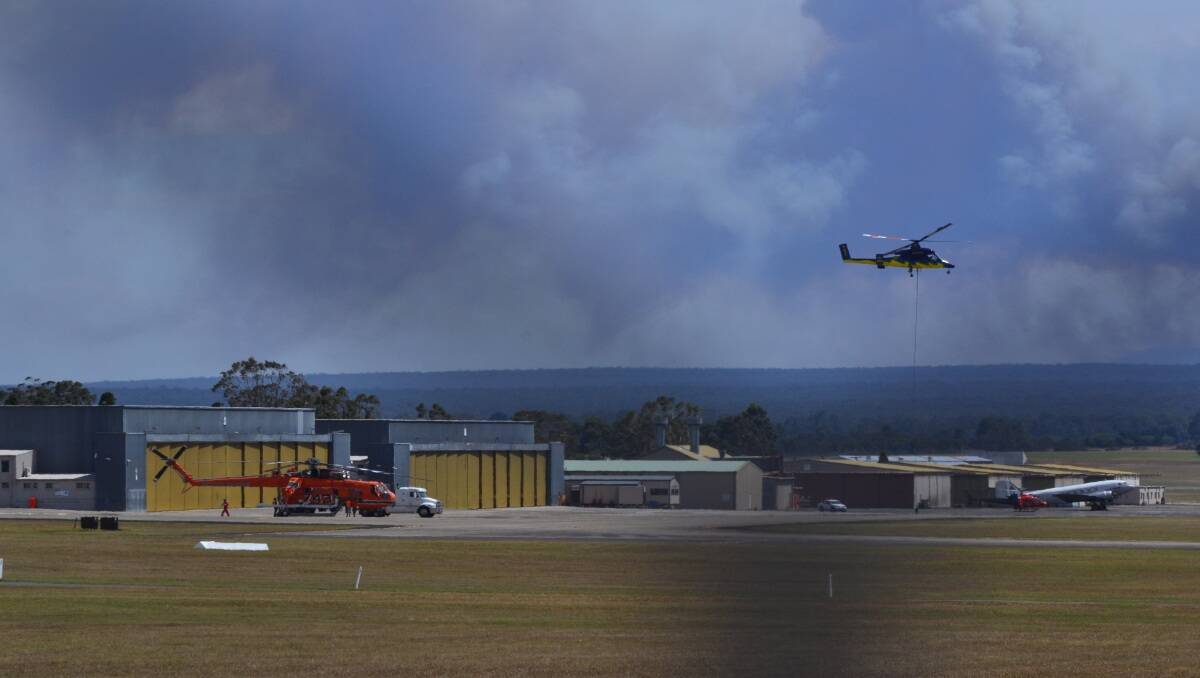 caption: A water bombing helicopter leaves from HMAS Albatross west of Nowra to assist with the battle against the fire at Deans Gap which broke containment lines this afternoon. Photo by Adam Wright 