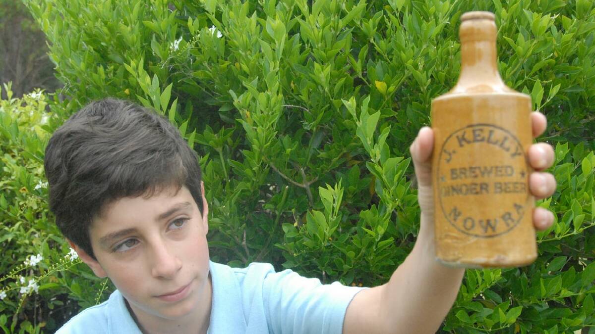 HISTORICAL FIND: Woollamia youngster Josh Caruana shows off his find, a ceramic ginger beer bottle from Nowra Cordial factory owner Jim Kelly.