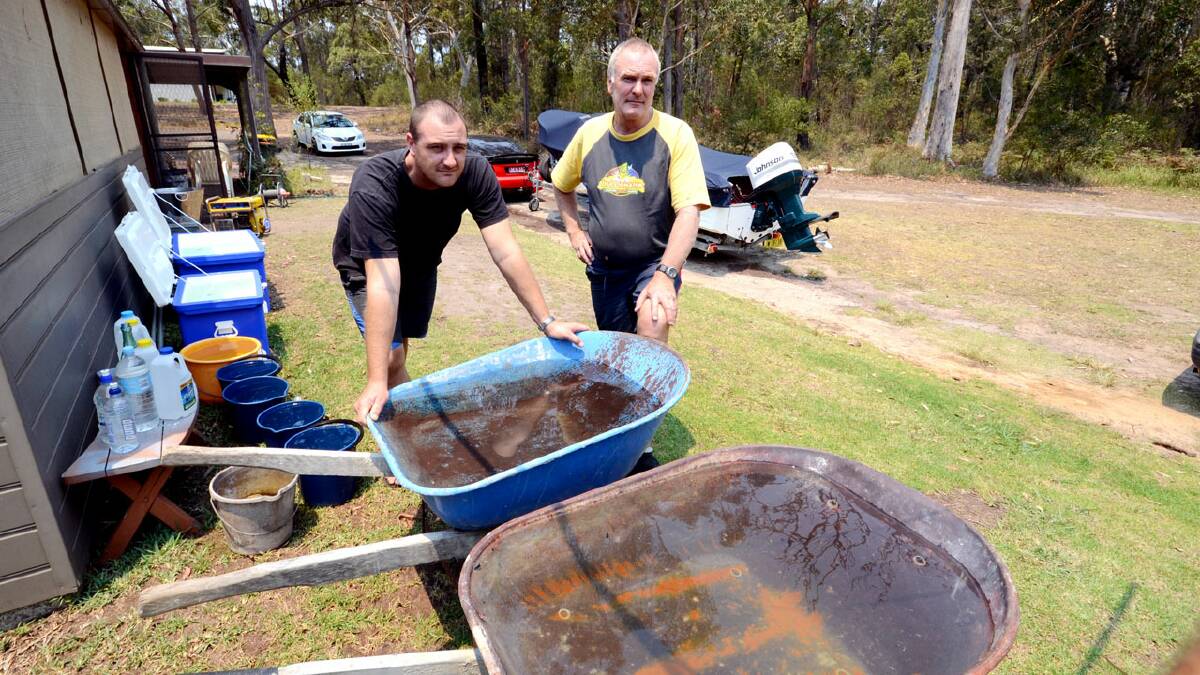 STAY AND DEFEND: Nathan and Greg Todhunter with their water supply were determined to stay and defend their property that was threatened by fire west of Sussex Inlet in January.